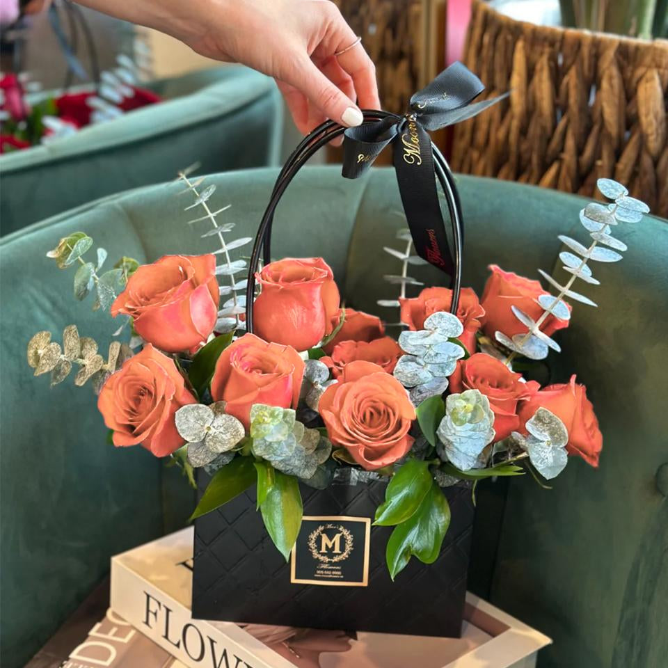 Dozen Peach roses arranged in a modern basket