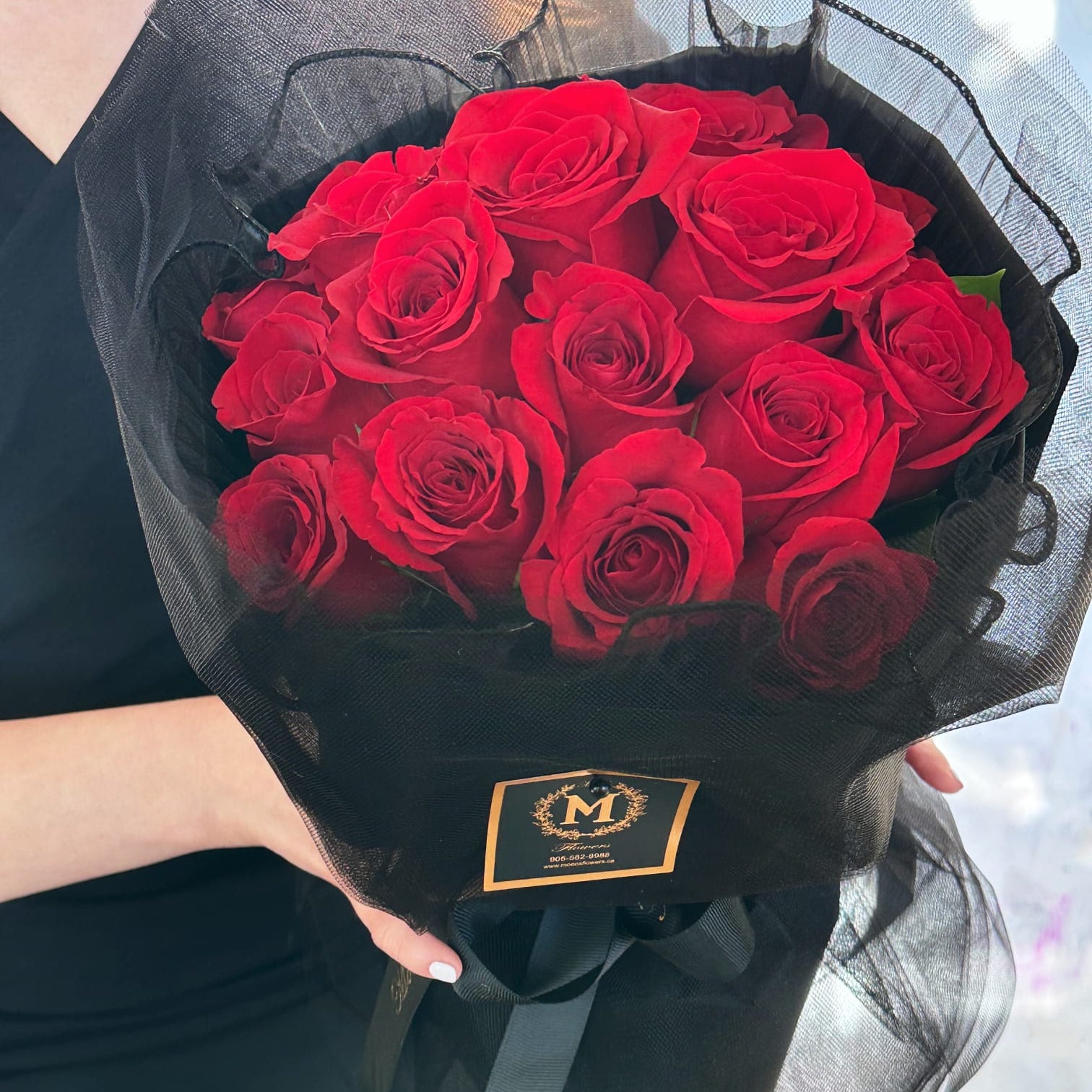 Handheld red rose round bouquet showing dense volume and rich red color