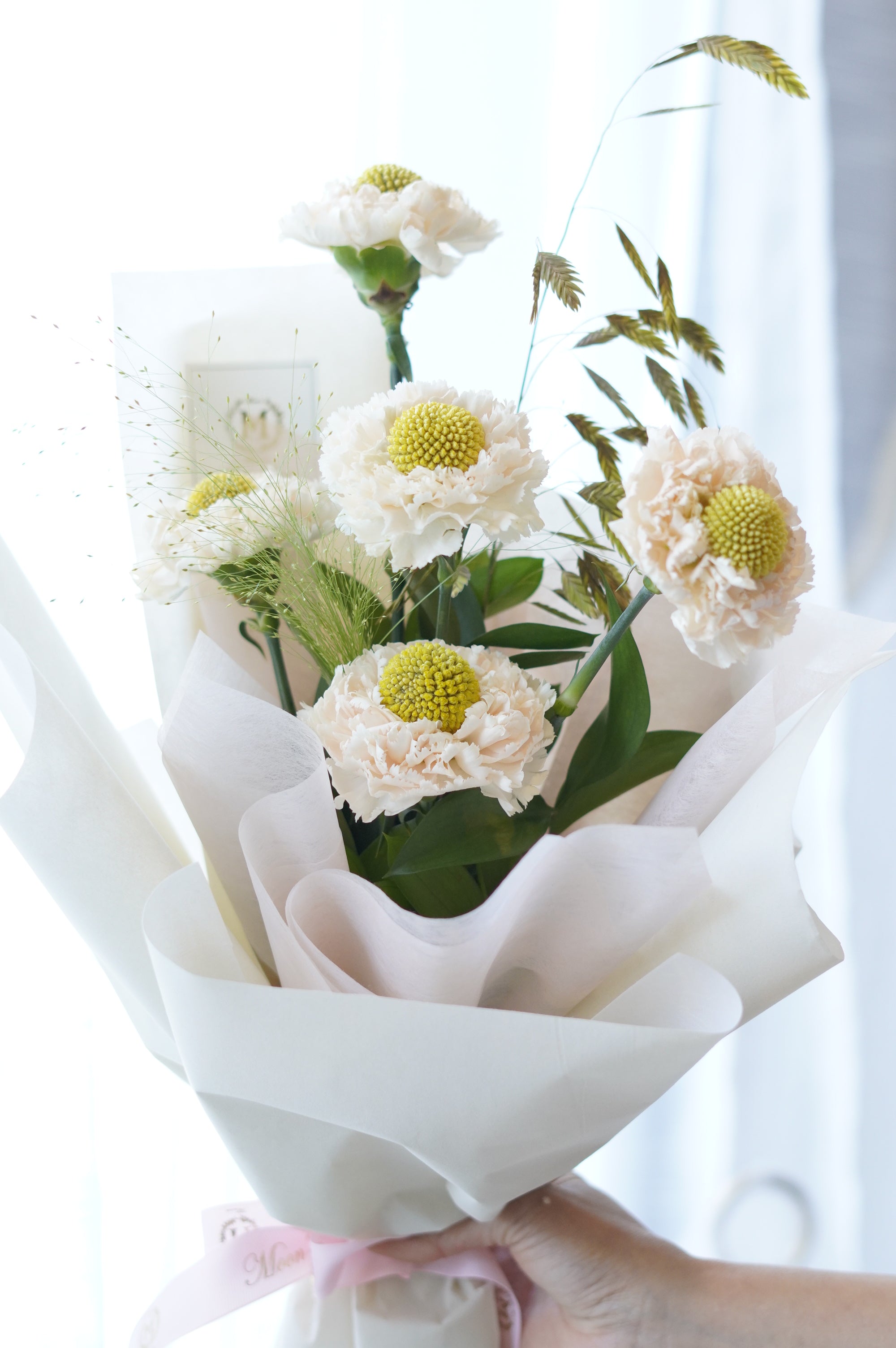 Elegant white carnation bouquet in Korean-style wrapping held by hand – fresh flower bouquet delivery GTA
