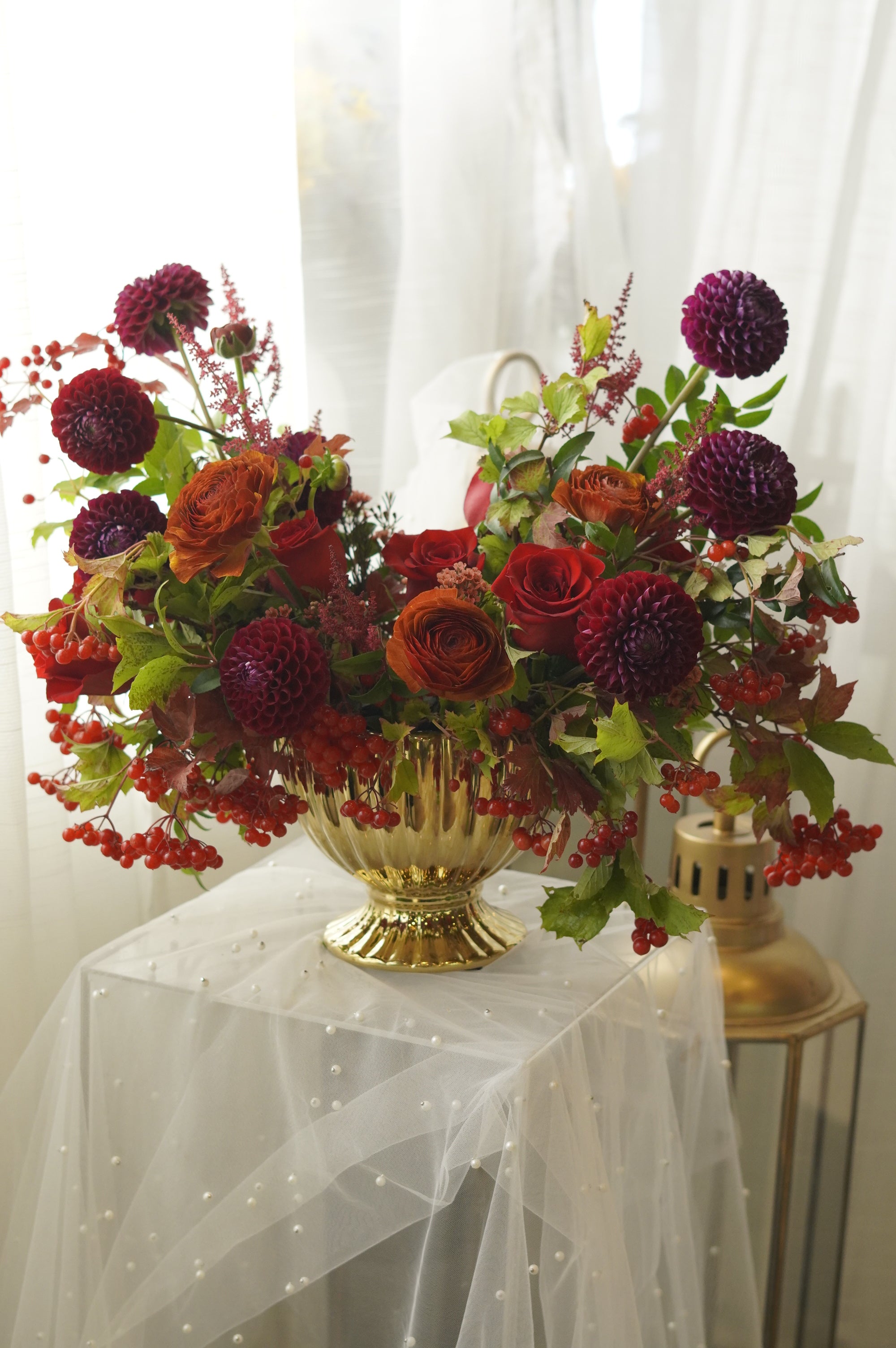 Luxury autumn floral centerpiece with roses, burgundy blooms, and seasonal foliage