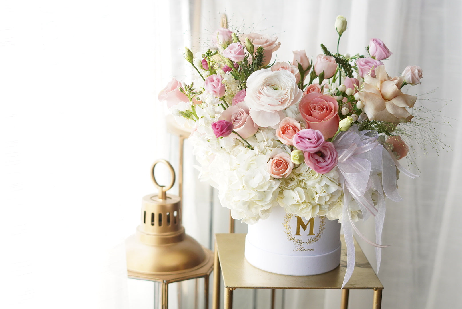 Elegant pastel flower box with pink and white blooms arranged in luxury hat box