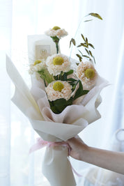 Close-up of blush white carnations with yellow-green button centres and wild grass accents – Moon's Flowers Toronto
