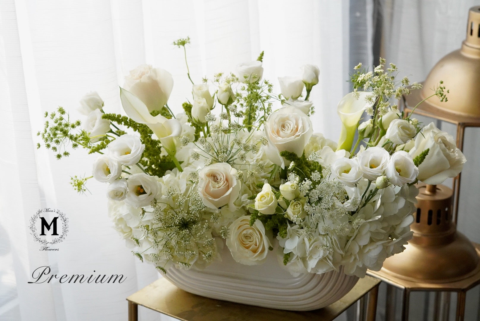 Floral arrangement in a white vase on a gold stand with a blurred background