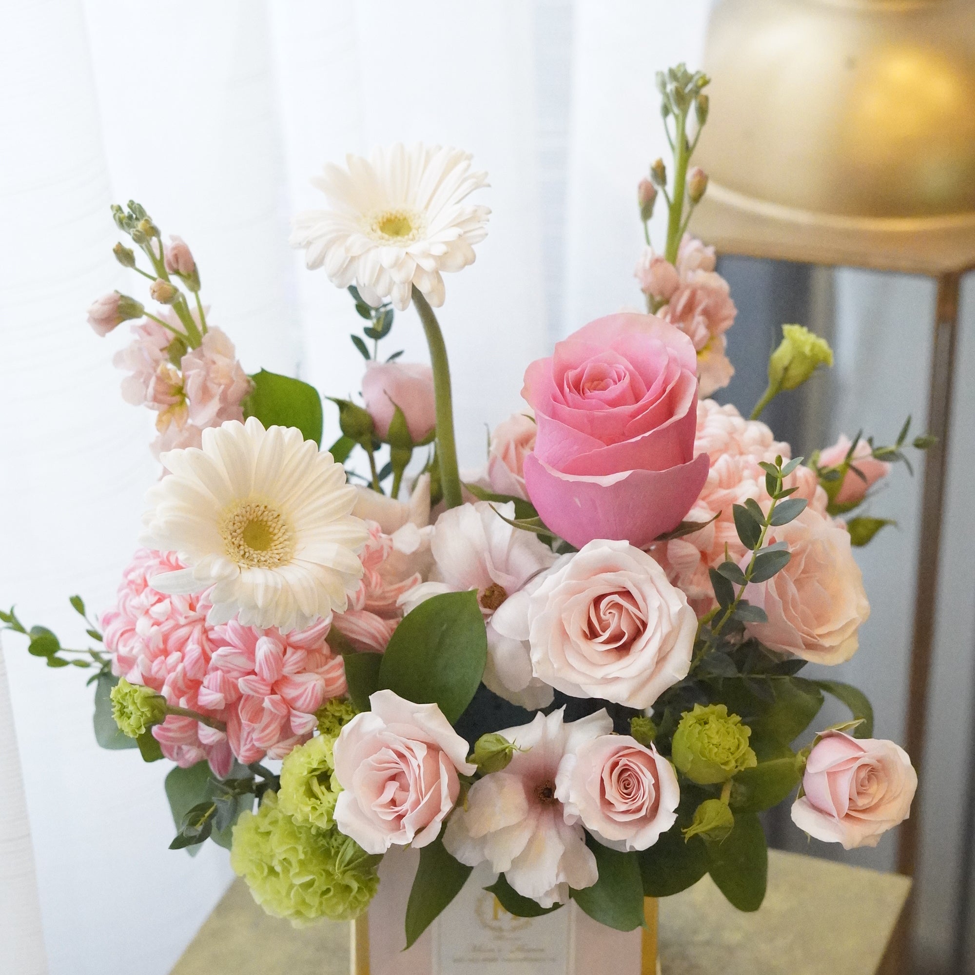 A heartfelt Mother's Day floral arrangement in a clean gift box, featuring elegant pink roses and soft colored blooms to express love and gratitude to Mom.