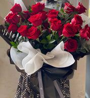 A stunning Mother's Day bouquet of premium red roses, elegantly hand-tied with black and white decorative wrapping and a grey signature ribbon. This classic romantic arrangement by Moon's Flowers Toronto is available for same-day delivery