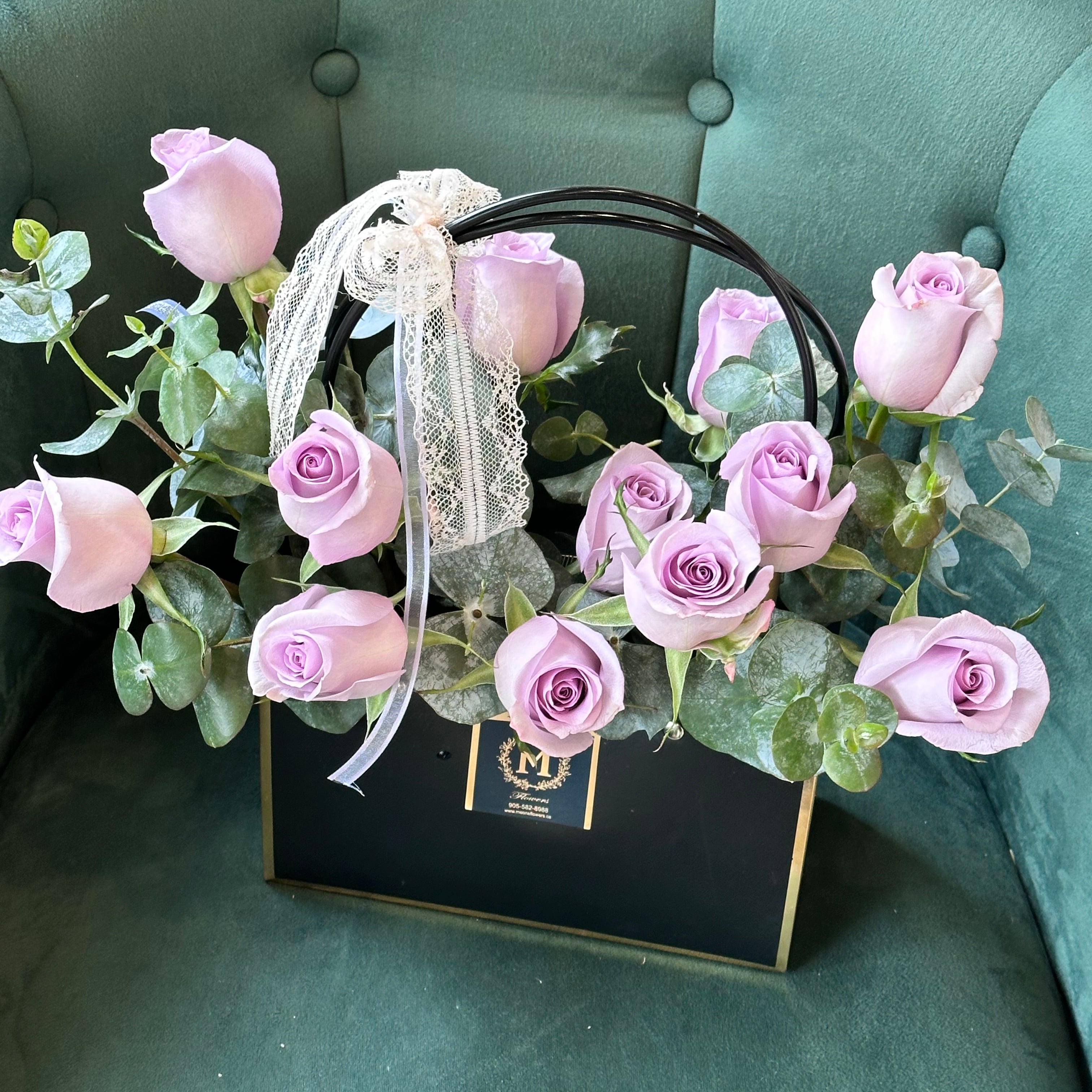 Lavender rose basket arrangement featuring light purple roses with eucalyptus
