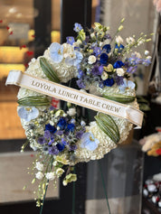 Blue and white sympathy flower wreath with a personalized 'Remembered and in our hearts' banner