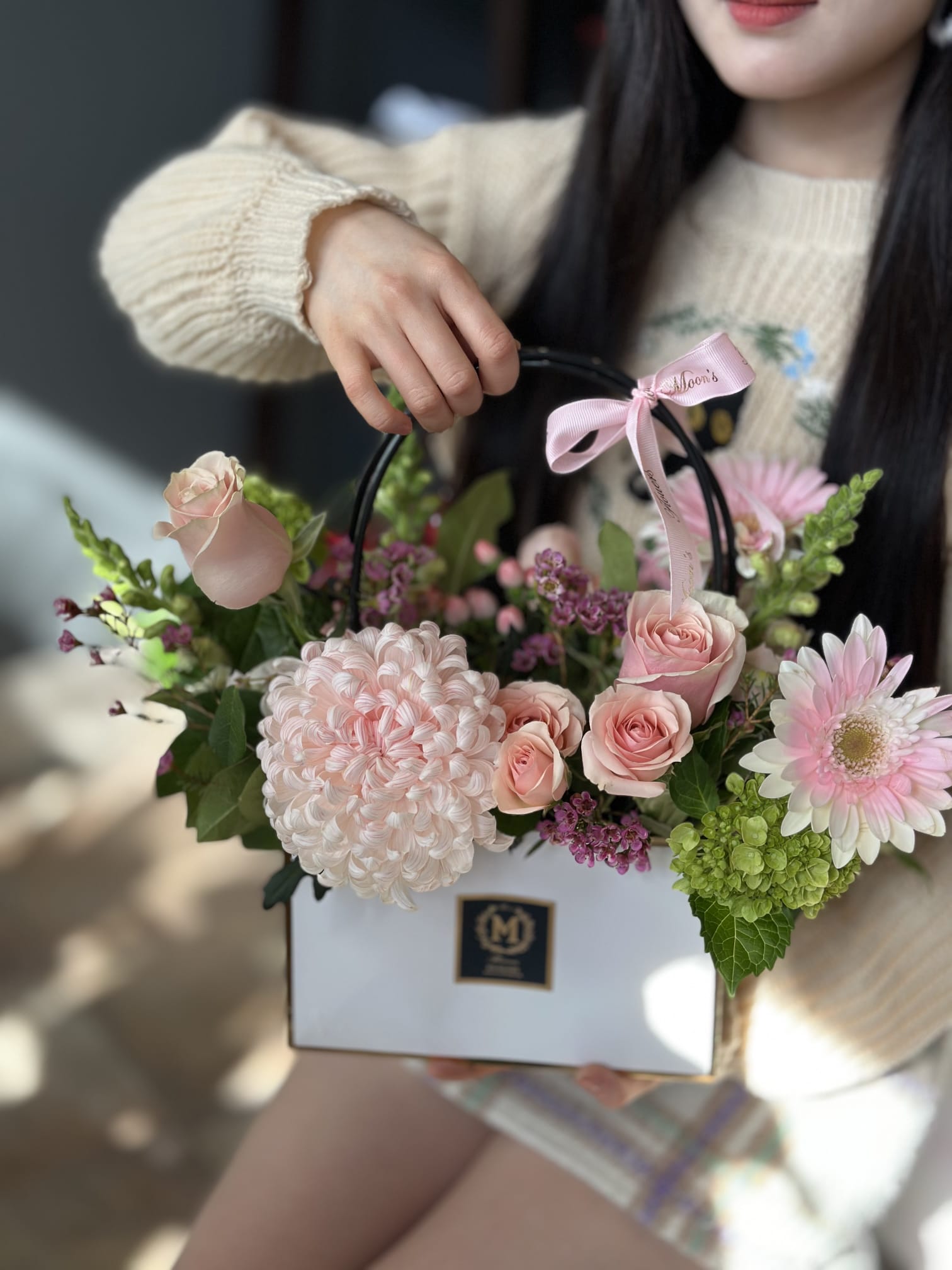 Chic floral gift bag from Moon's flowers featuring a large chrysanthemum, roses, and gerberas. a stylish and convenient ready to gift flower arrangement for delivery in Toronto and Oakville