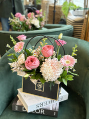 Chic ready to gift floral bag arrangement by Moons Flowers with pink garden Roses, chrysanthemum, and gerbera daisy. Convenient same-day delivery available in Oakville