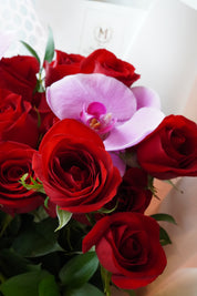 Close-up of a pink orchid accent in a rose bouquet
