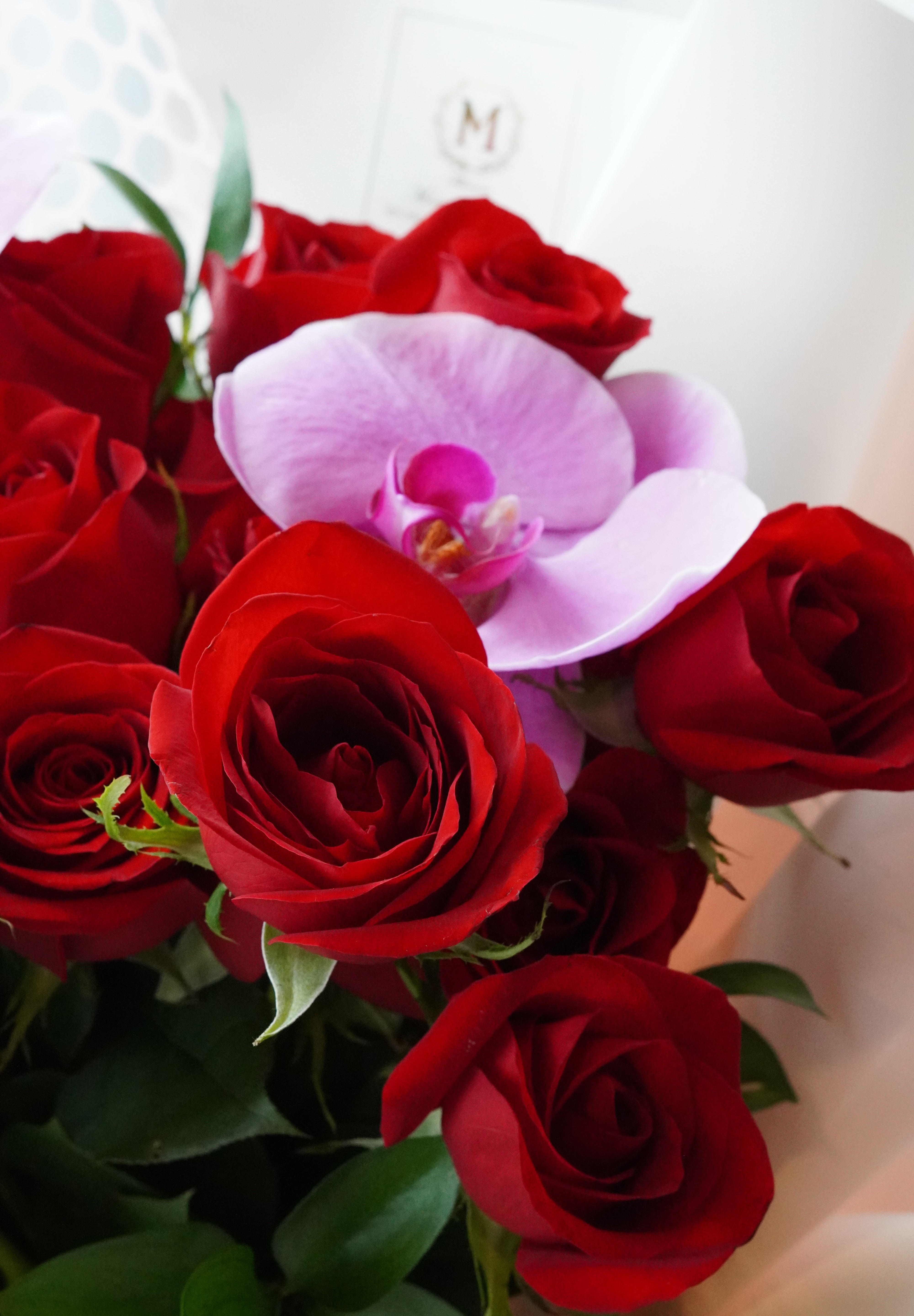 Close-up of a pink orchid accent in a rose bouquet