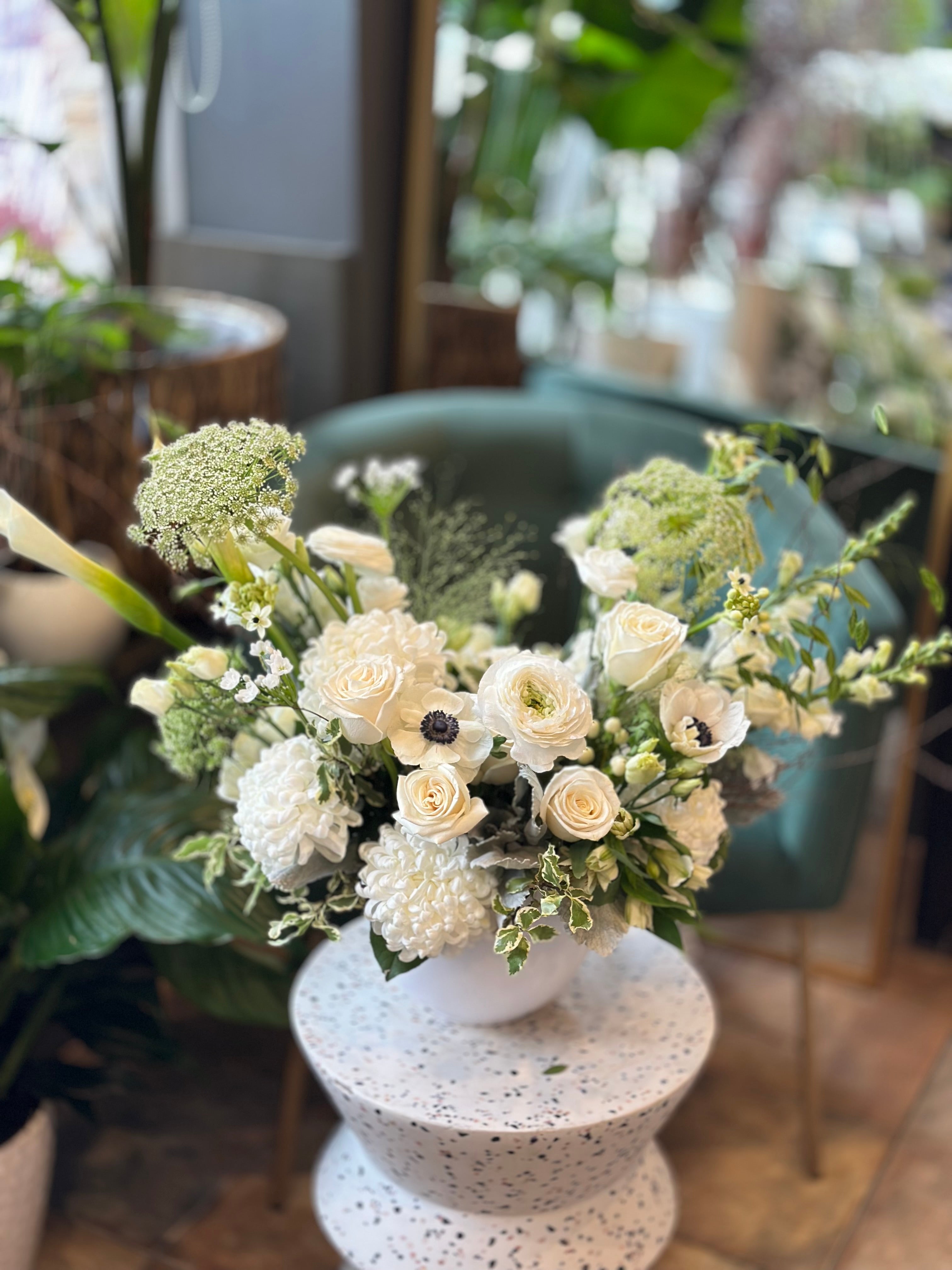 Close-up of premium white roses and lilies in a grieving sympathy floral display