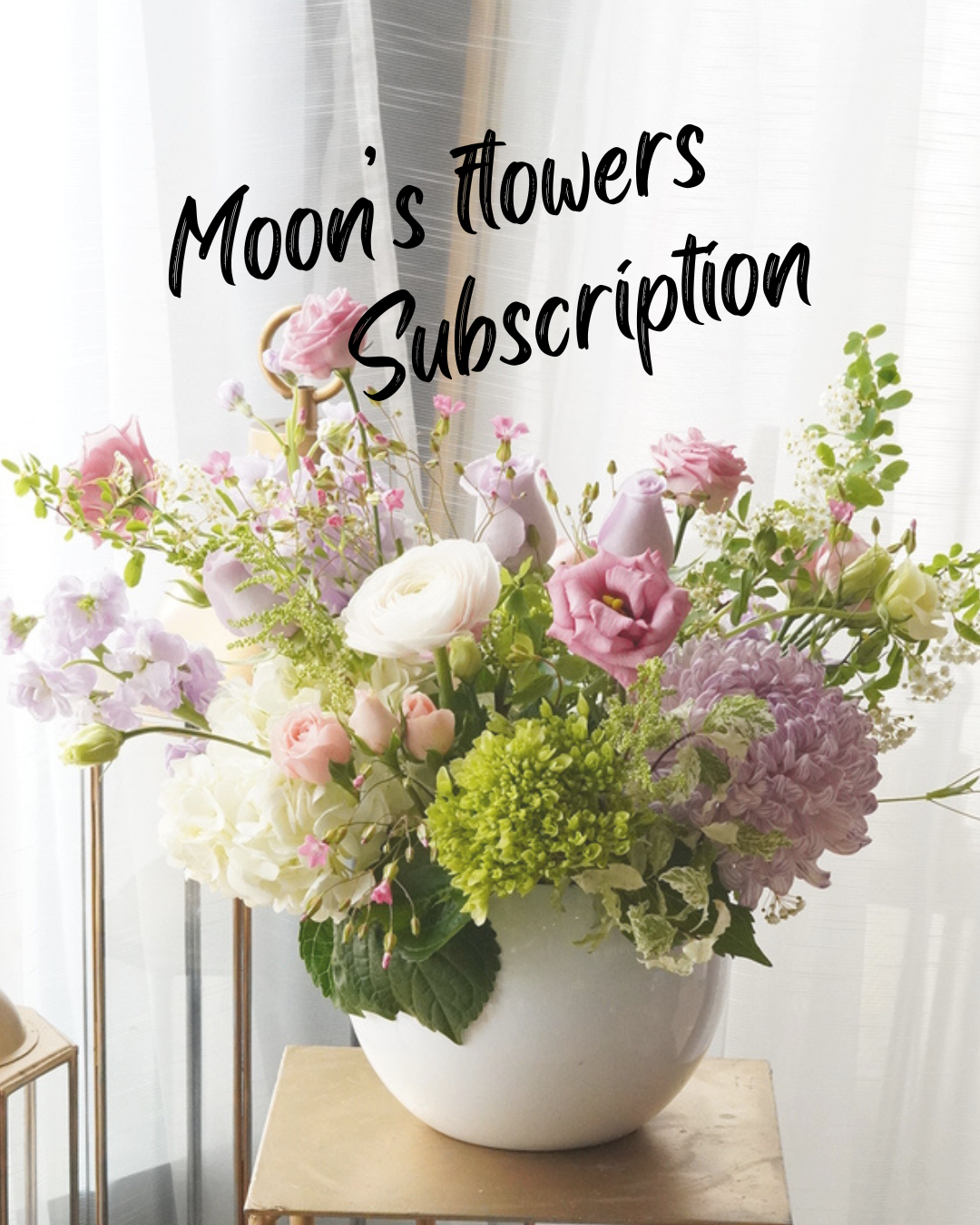 Moon's Flowers Designer's Choice flower arrangement subscription in a white vase with seasonal pink and purple flowers