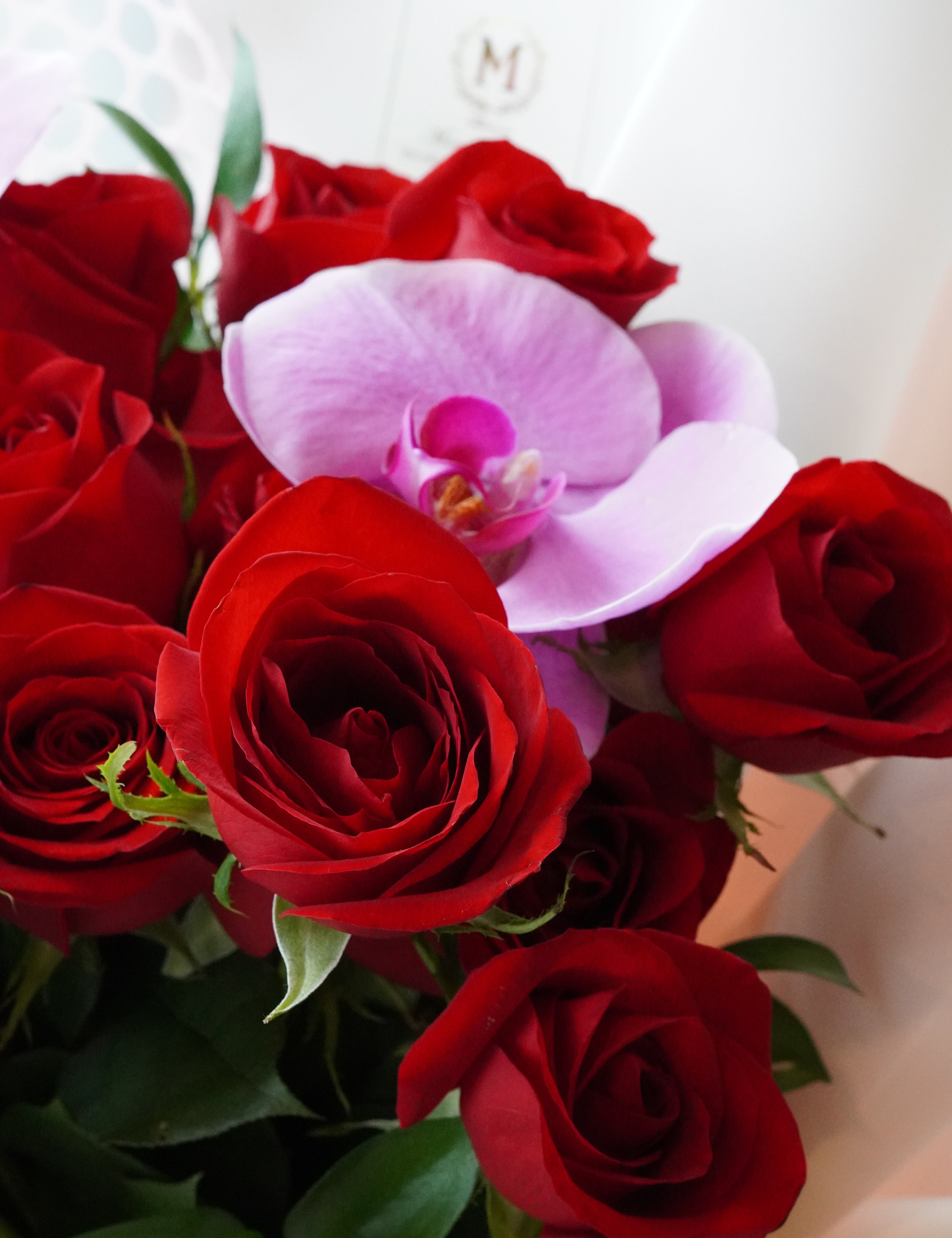 Close-up of a white orchid accent in a rose bouquet