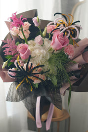 Pink roses and white hydrangea with black, pink and gold firework-inspired accents — graduation bouquet