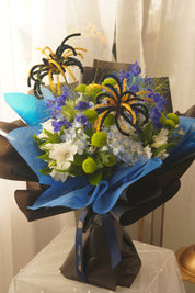 Blue Horizon graduation bouquet with blue and white flowers, green chrysanthemums and blue-black wrapping for Toronto graduates