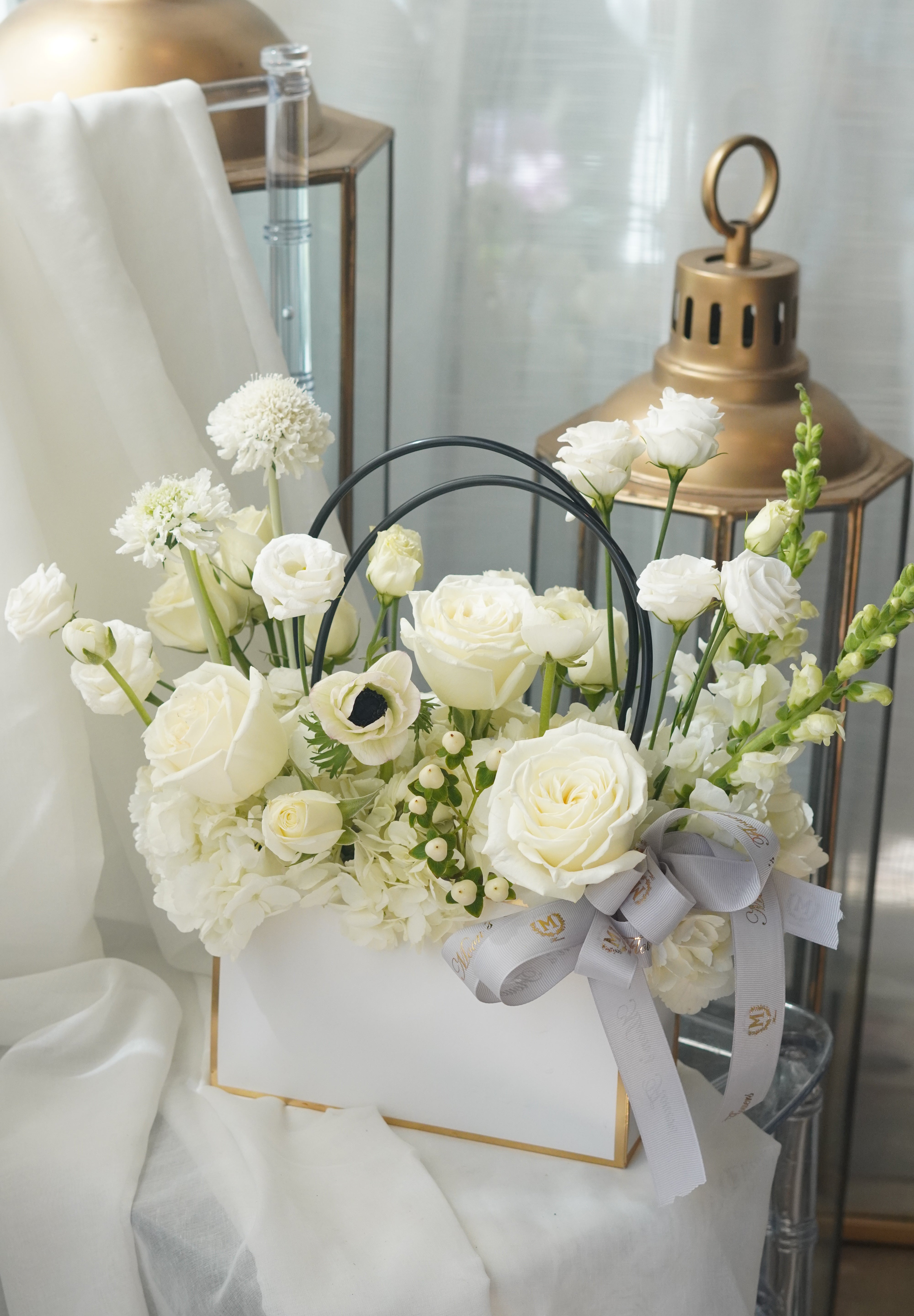 Vibrant pink and green floral basket featuring Gerber daisies and green hydrangeas in a modern white gift box with gold accents.