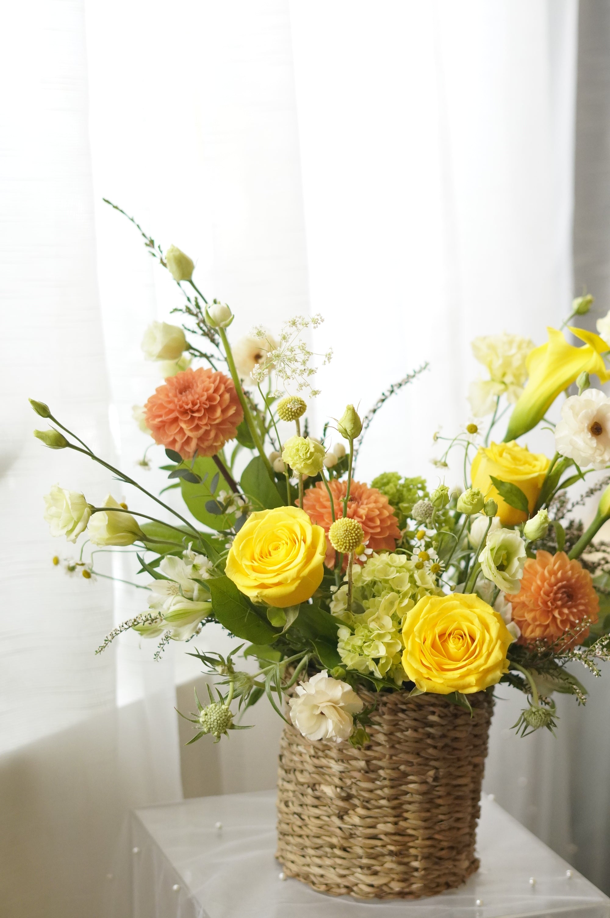 Yellow and orange seasonal flower basket with roses and garden flowers