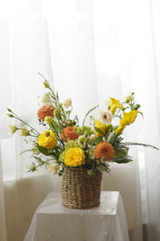 Yellow and orange seasonal flower basket with roses and garden flowers