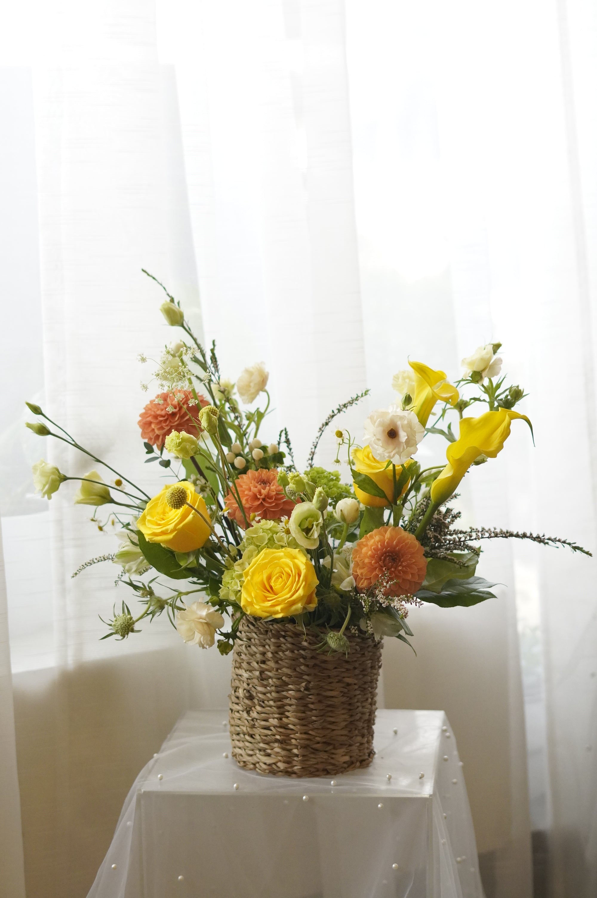 Yellow and orange seasonal flower basket with roses and garden flowers