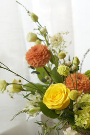 Yellow and orange seasonal flower basket with roses and garden flowers