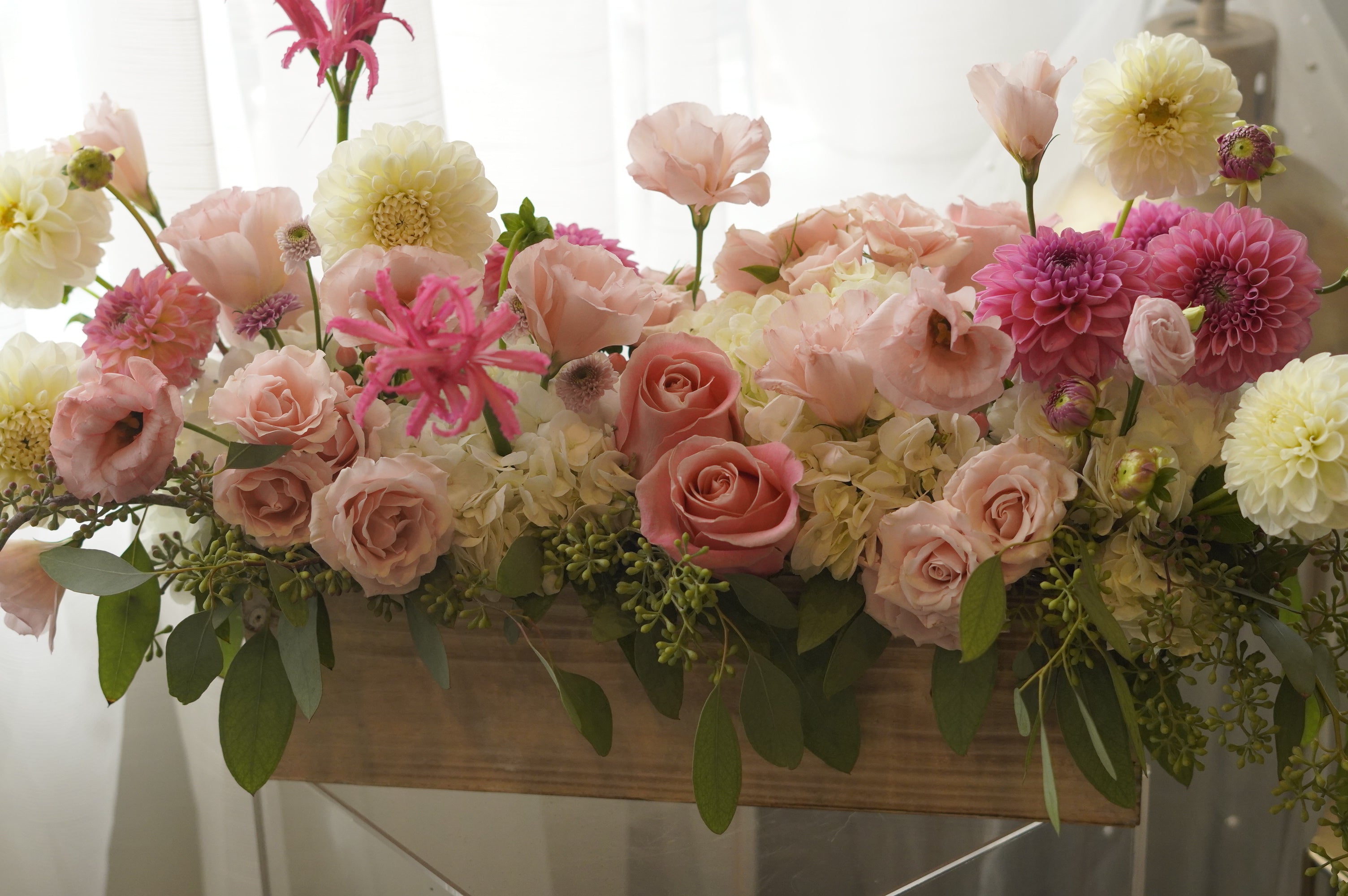 Close-up of pink and ivory seasonal blooms with textured greenery