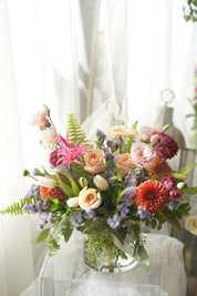Tangerine garden-style flowers in clear glass vase — same-day GTA flower delivery