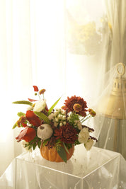 Close-up of white berries, ivory pumpkin and red autumn leaves in the arrangement