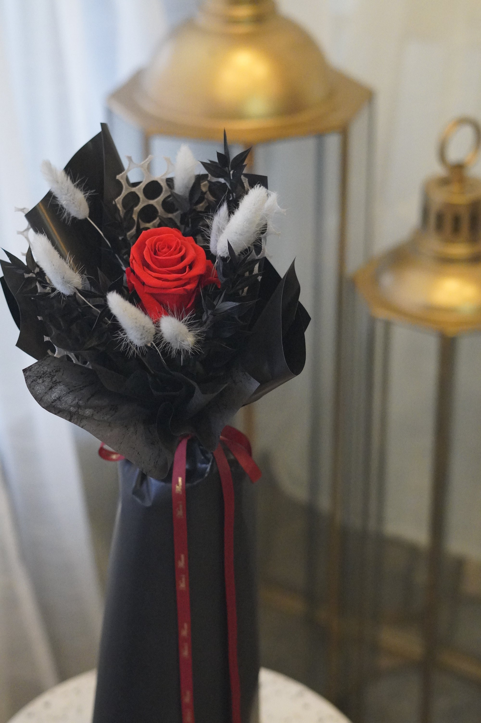 Single long stem preserved rose with dried flowers in elegant black signature wrapping by Moon’s Flowers