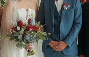 Bride holding a lush hand-tied bouquet of deep red roses, red dahlias, powder blue delphiniums, white tulips, and eucalyptus — Red & Blue Romance Bridal Bouquet by Moon's Flowers Toronto