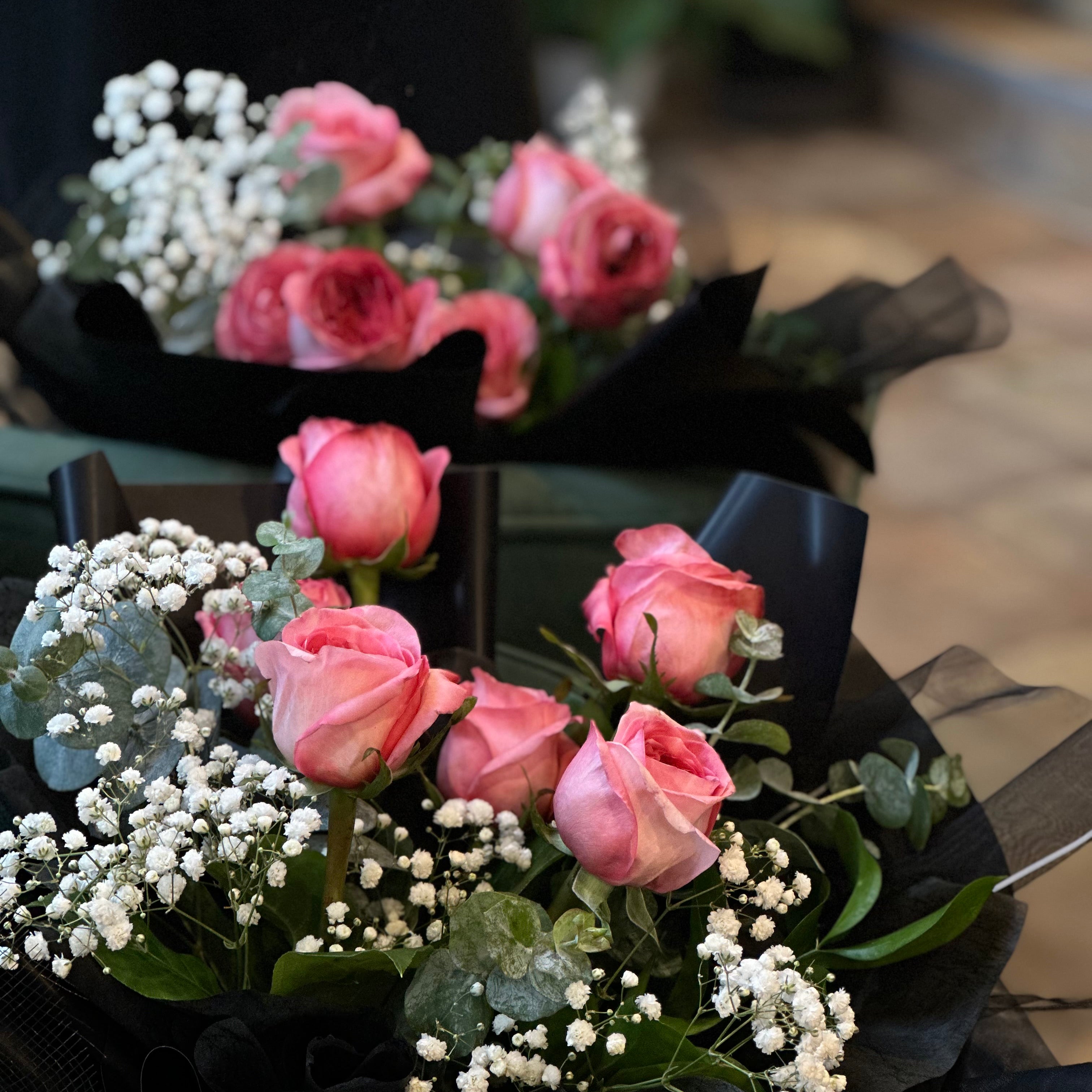 Close-up of fresh half dozen roses showing petal detail and elegant wrapping