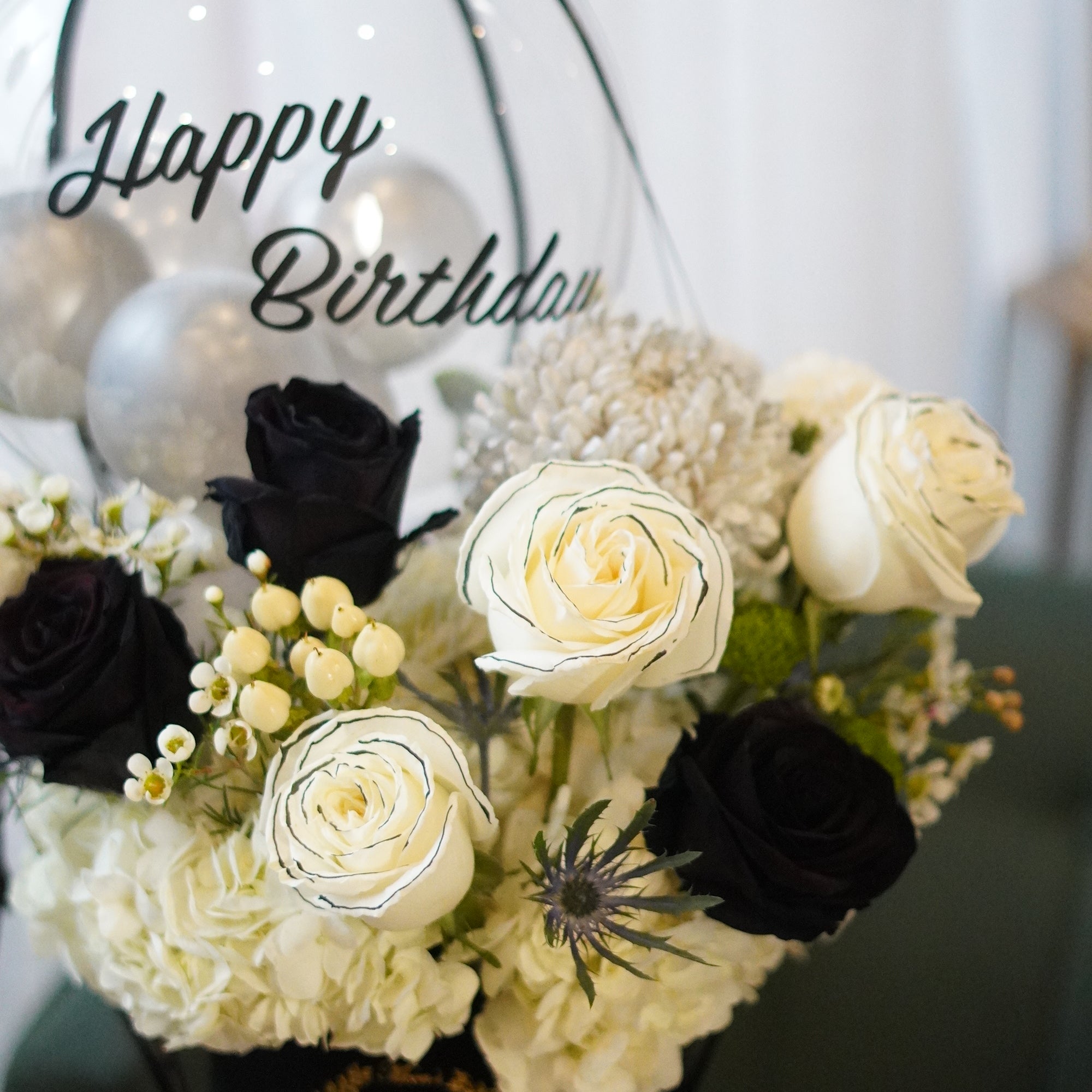 Close-up of black and white roses in a velvet box arrangement