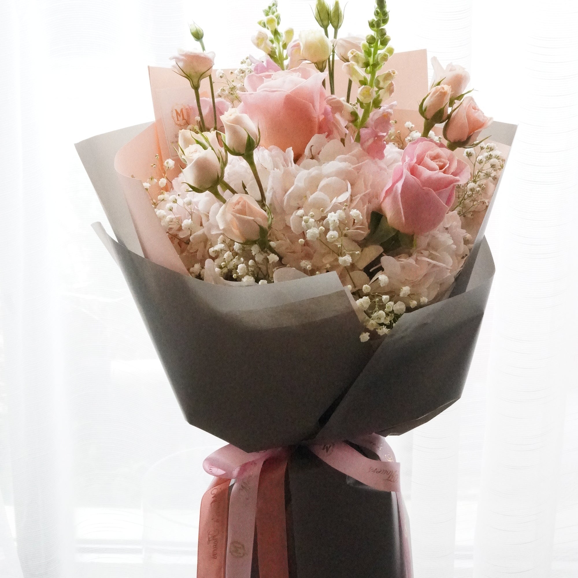 Elegant pink rose bouquet with white filler flowers and stylish grey wrapping