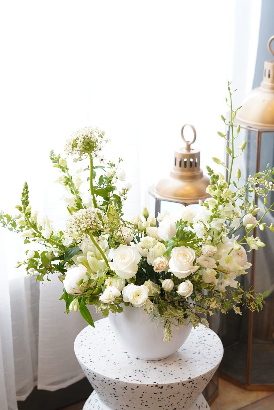 Elegant white condolence flower arrangement in a ceramic vase for funeral services in Toronto