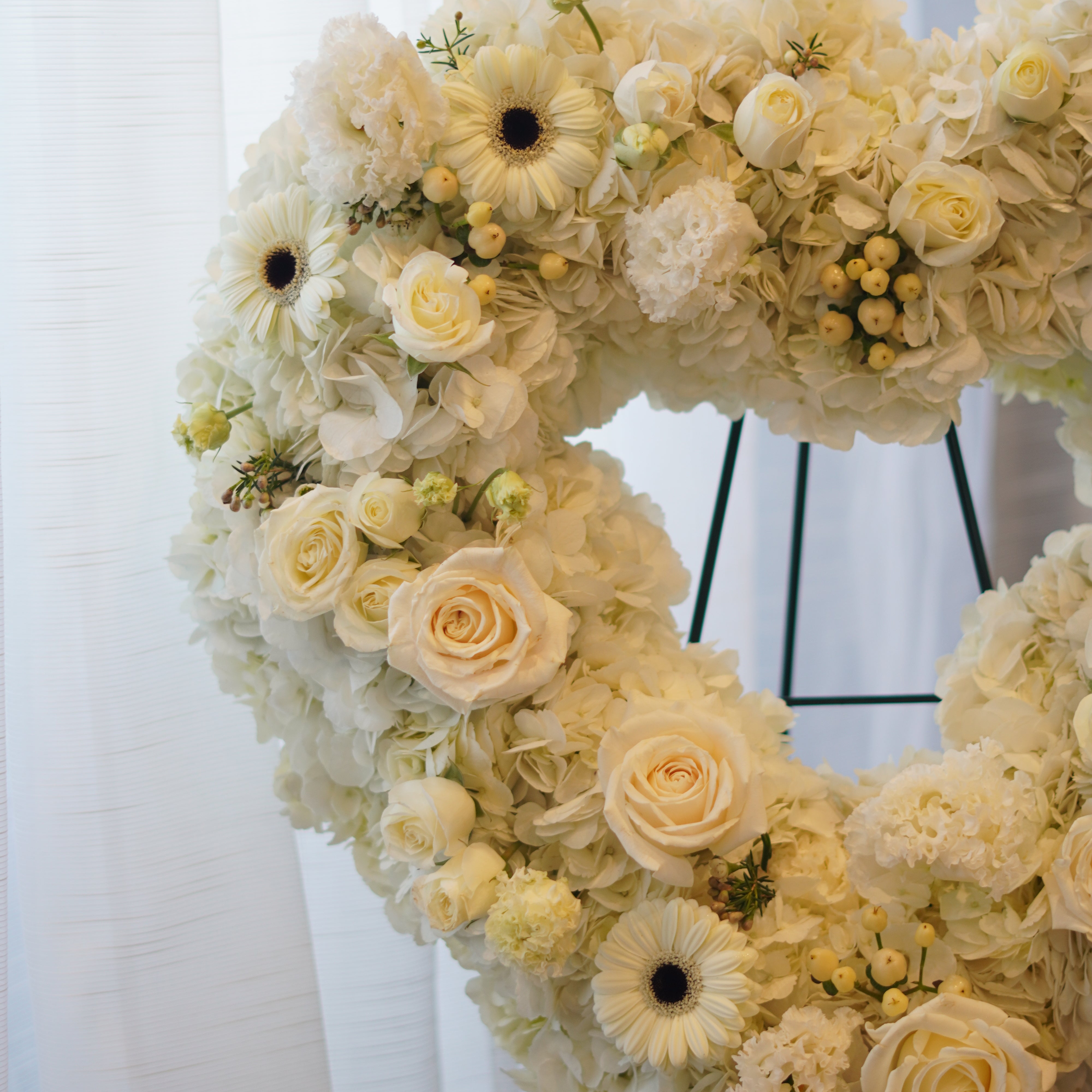 Everlasting Love white heart funeral wreath on a standing easel for same-day flower delivery in Toronto.