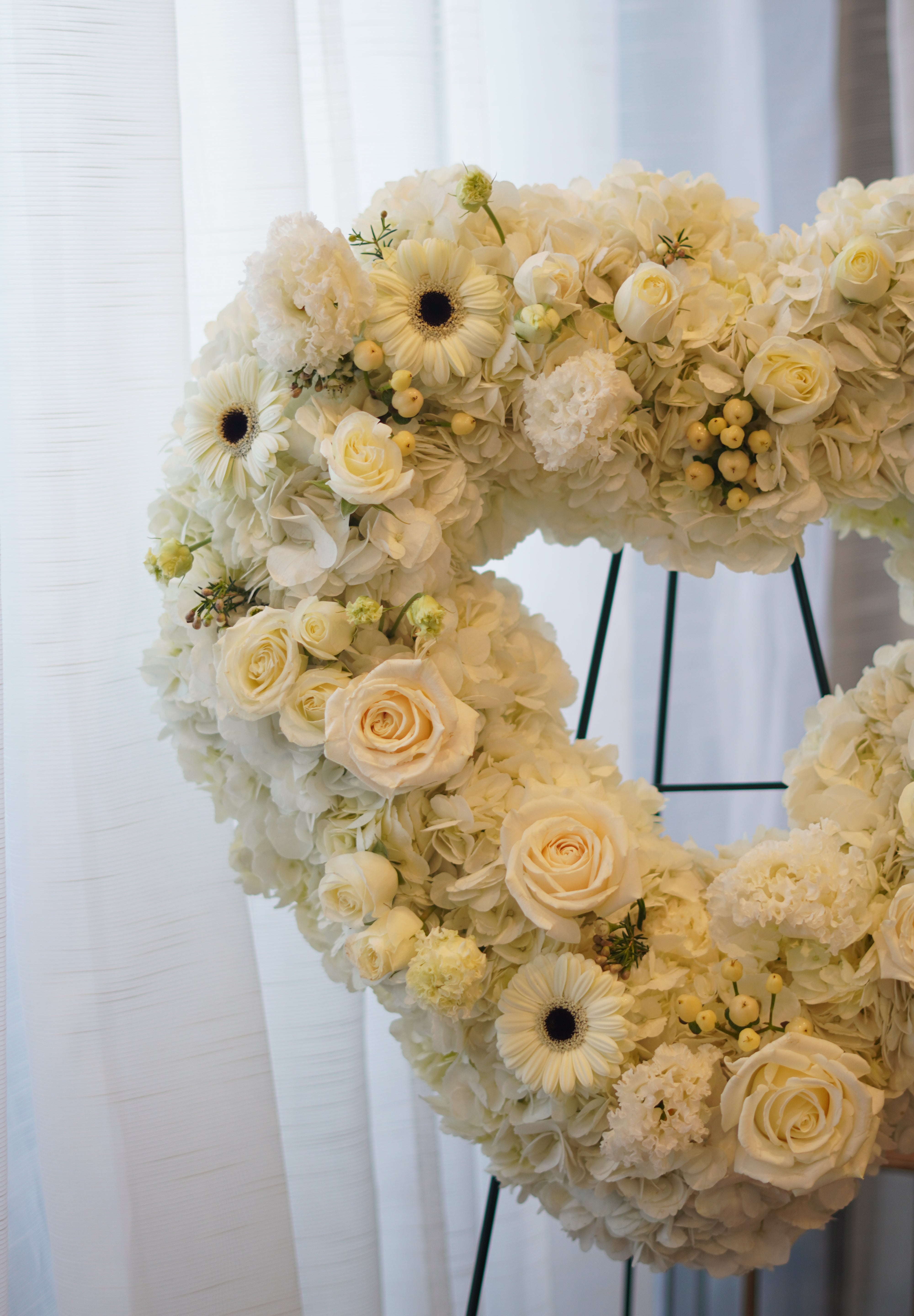 Everlasting Love white heart funeral wreath on a standing easel for same-day flower delivery in Toronto.