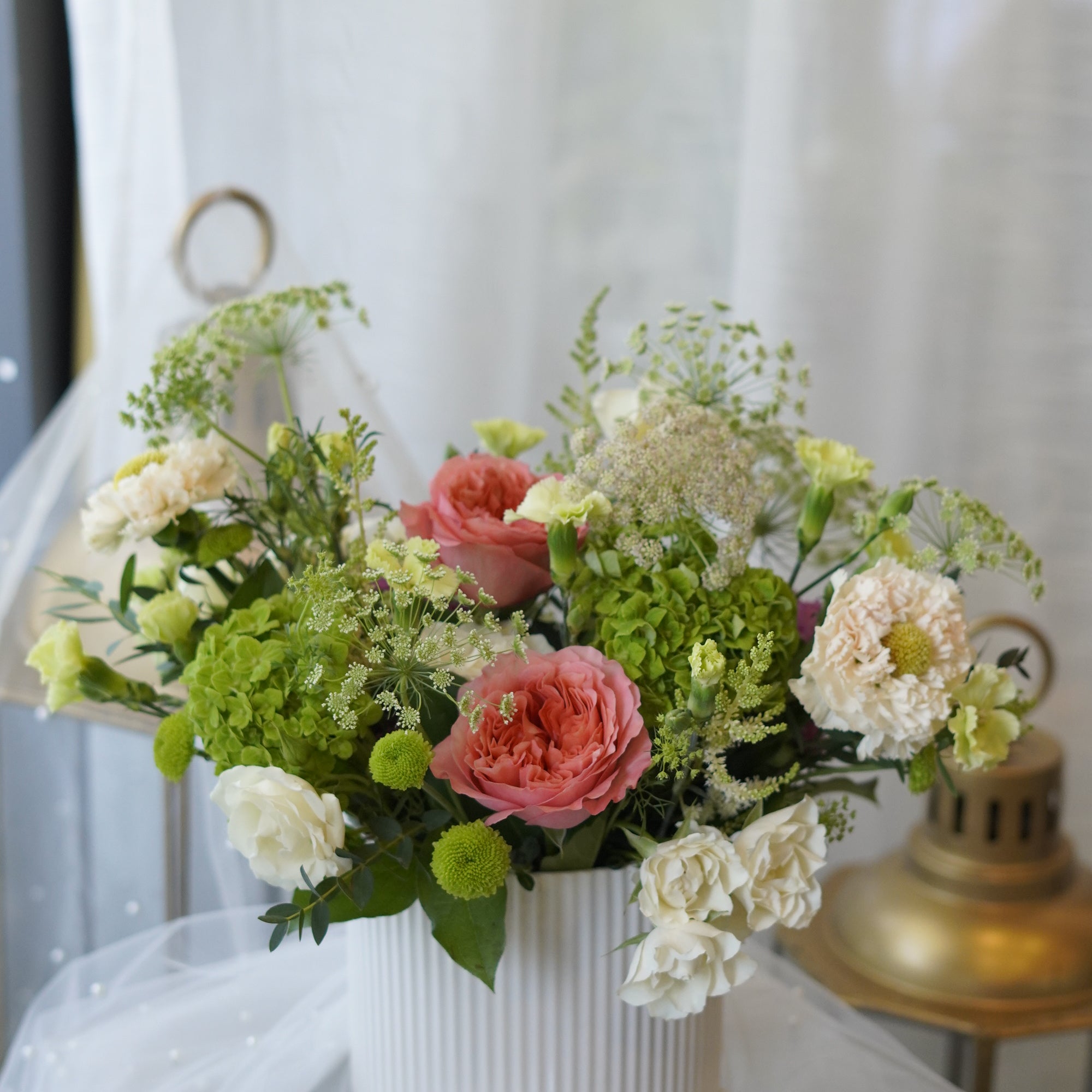 Fresh coral rose and green hydrangea dining table centerpiece designed for modern home décor and local flower delivery in Oakville and Toronto.