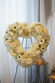 Heart-shaped funeral wreath with white roses, gerberas, and carnations for memorial services in Toronto.