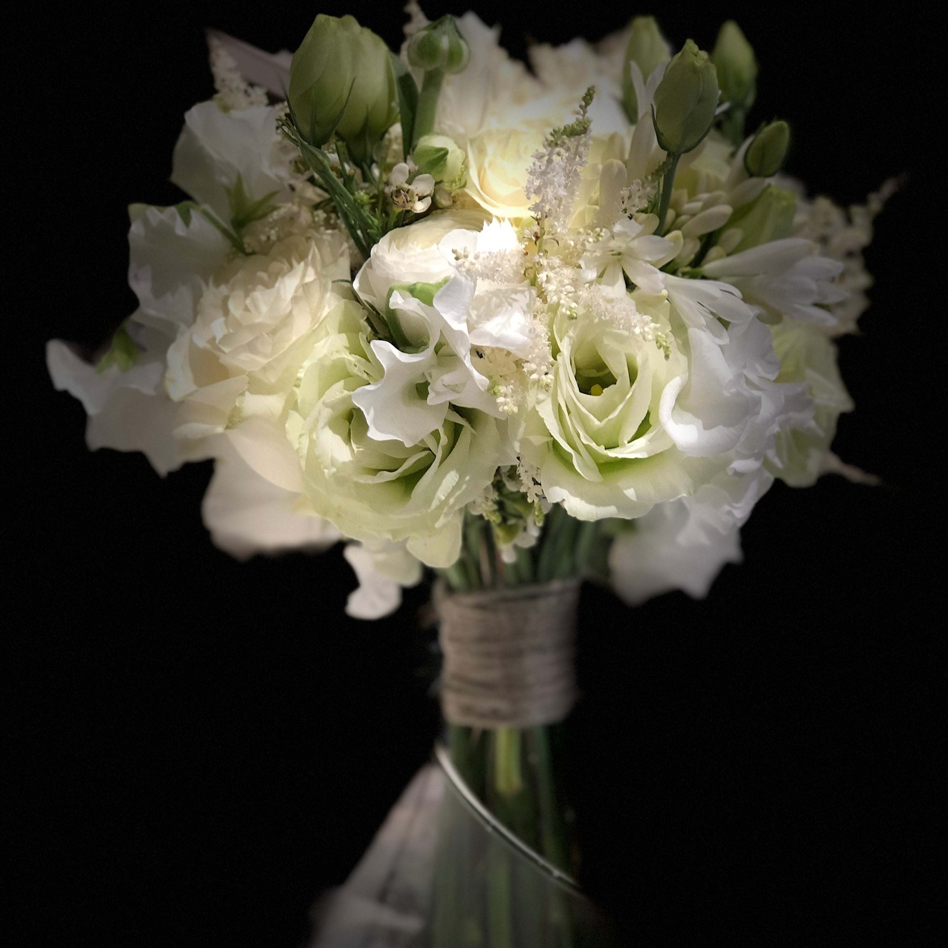elegant white bridal bouquet with lisianthus and ranunculus close up