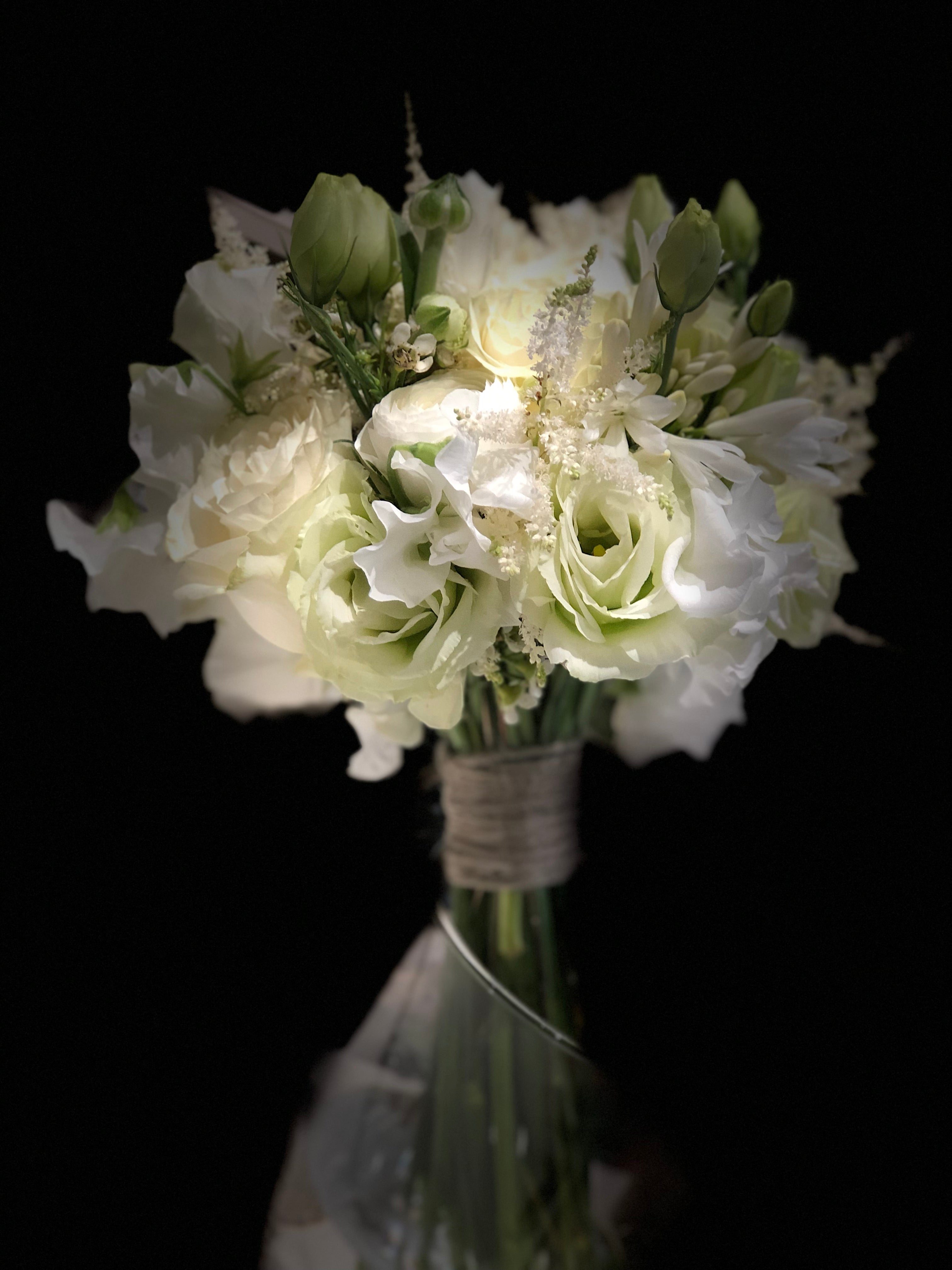 elegant white bridal bouquet with lisianthus and ranunculus close up