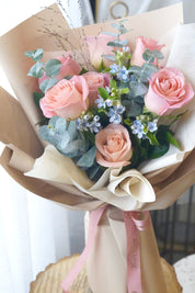 Close-up of blush pink roses with delicate blue accents highlighting soft color contrast