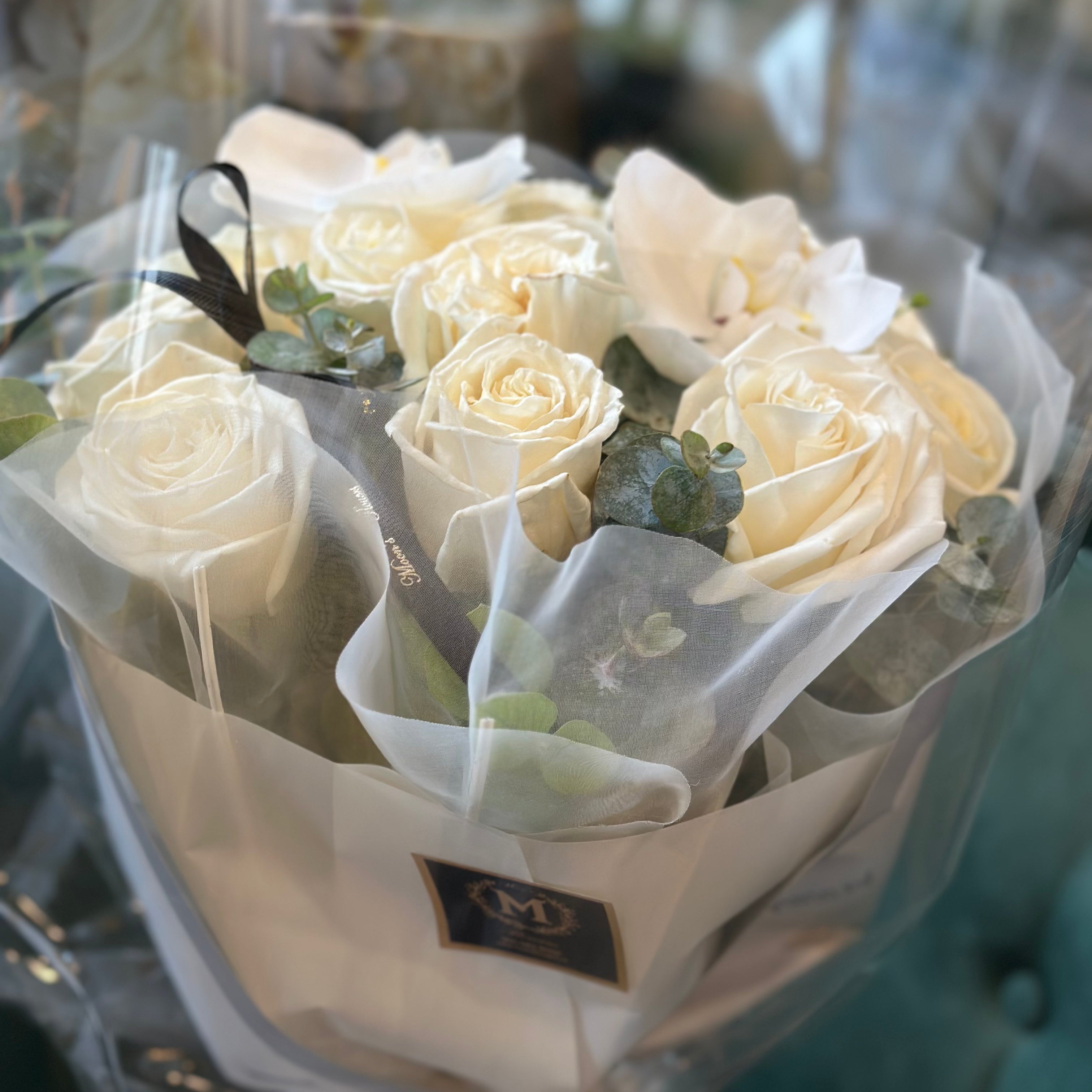 Close-up of Playa Blanca white roses arranged in a round bouquet
