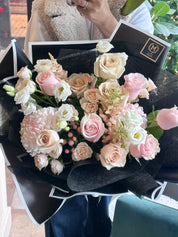 Luxury Mother's Day Signature bouquet featuring premium creamy white and soft pink roses in a chic black designer wrap. Hand-tied floral arrangement by Moon's Flowers, available for same-day delivery in Toronto and the GTA
