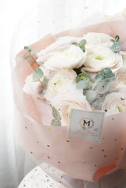 Luxury white ranunculus bouquet with star dotted pink wrapping paper. premium floral design by Moon's Flowers. Available for fast flower delivery in Oakville, Toronto, and the GTA-ideal for unique birthday or Mother's day gift 