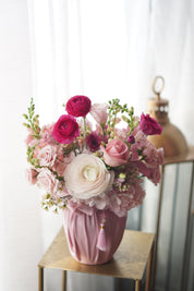Mother's Day floral arrangement in a pink fabric-wrapped vase featuring a large white ranunculus, magenta spray roses, and pink hydrangeas with a traditional Korean tassel. Luxury gift delivery in Toronto and Oakville