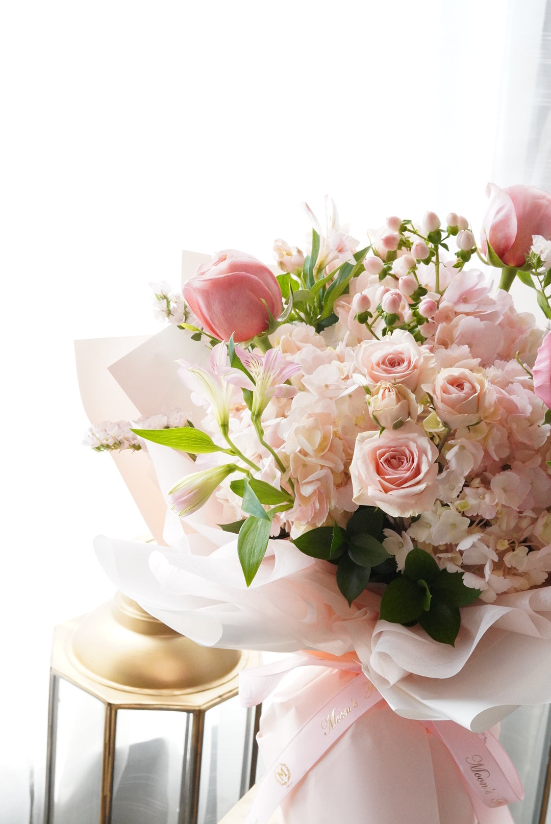 Bouquet of pink flowers with green leaves on a white background