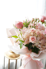 Bouquet of pink flowers with green leaves on a white background