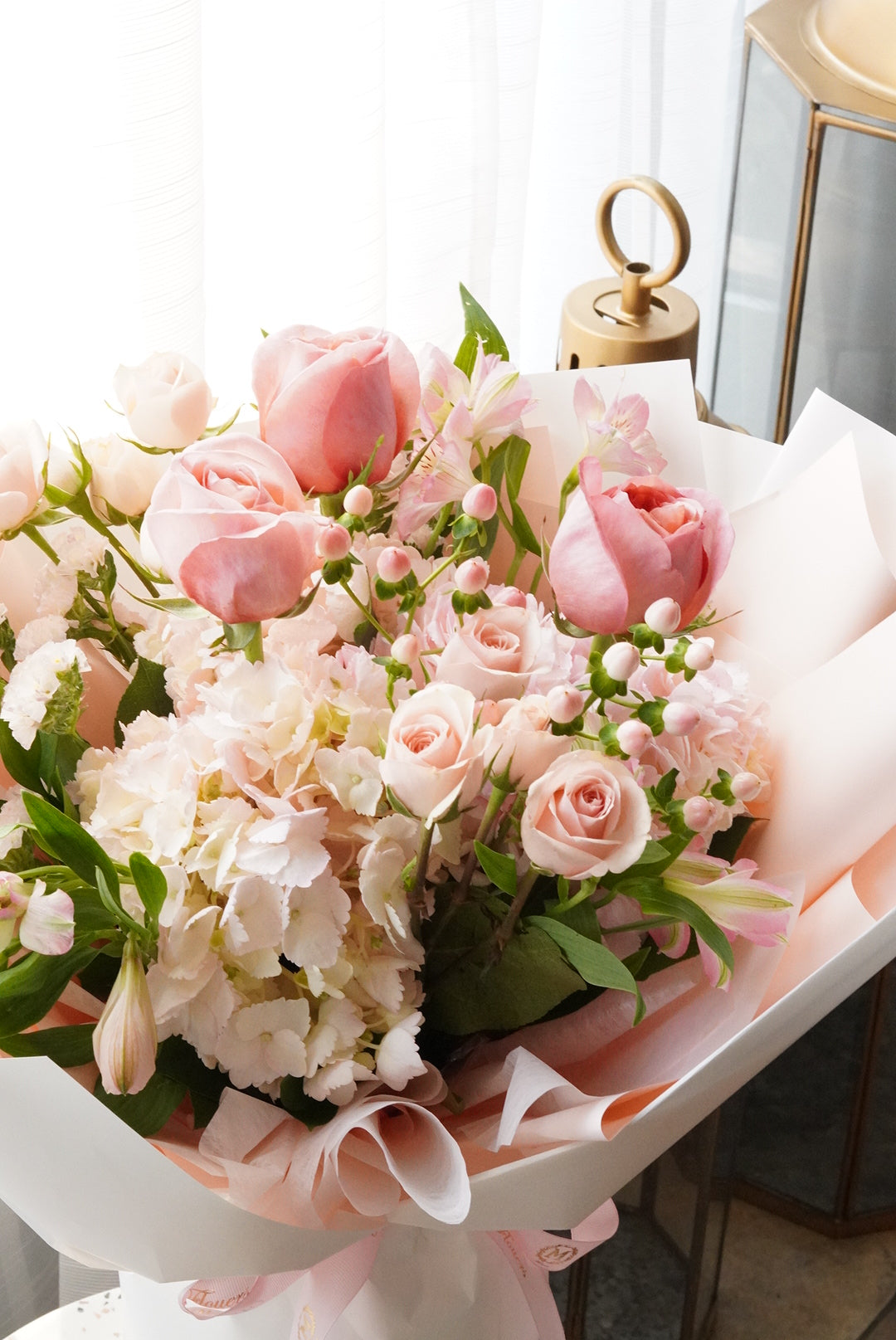 Bouquet of pink and white flowers with a gold key in the background
