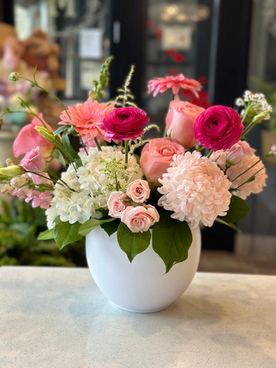 Pink Mother's Day flower arrangement with roses, gerbera daisies, and ranunculus in a white ceramic pot by Moon's Flowers Toronto.