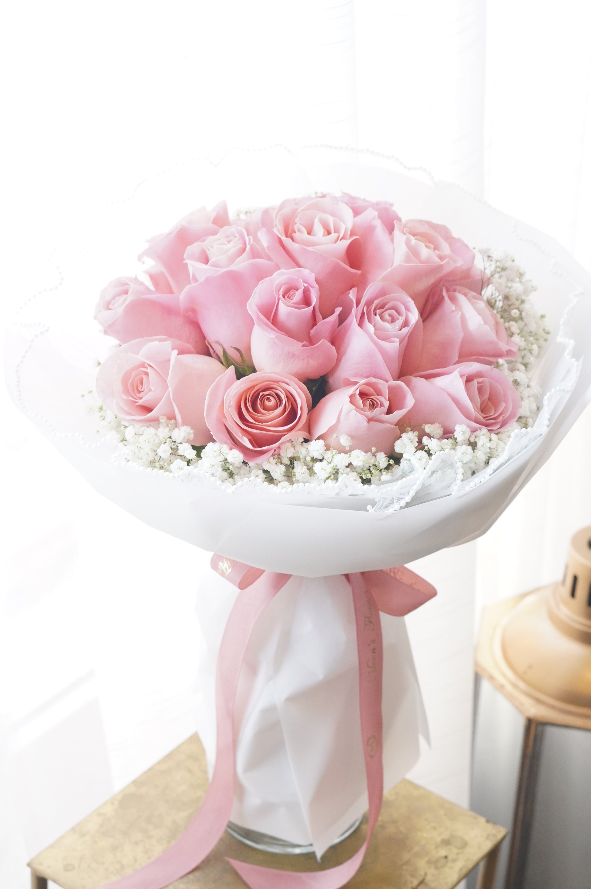 Bouquet of pink roses with a white ribbon on a white background for delivery across the GTA and Toronto